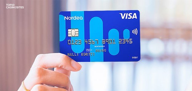 Close up of hand holding a blue Nordea Visa debit card